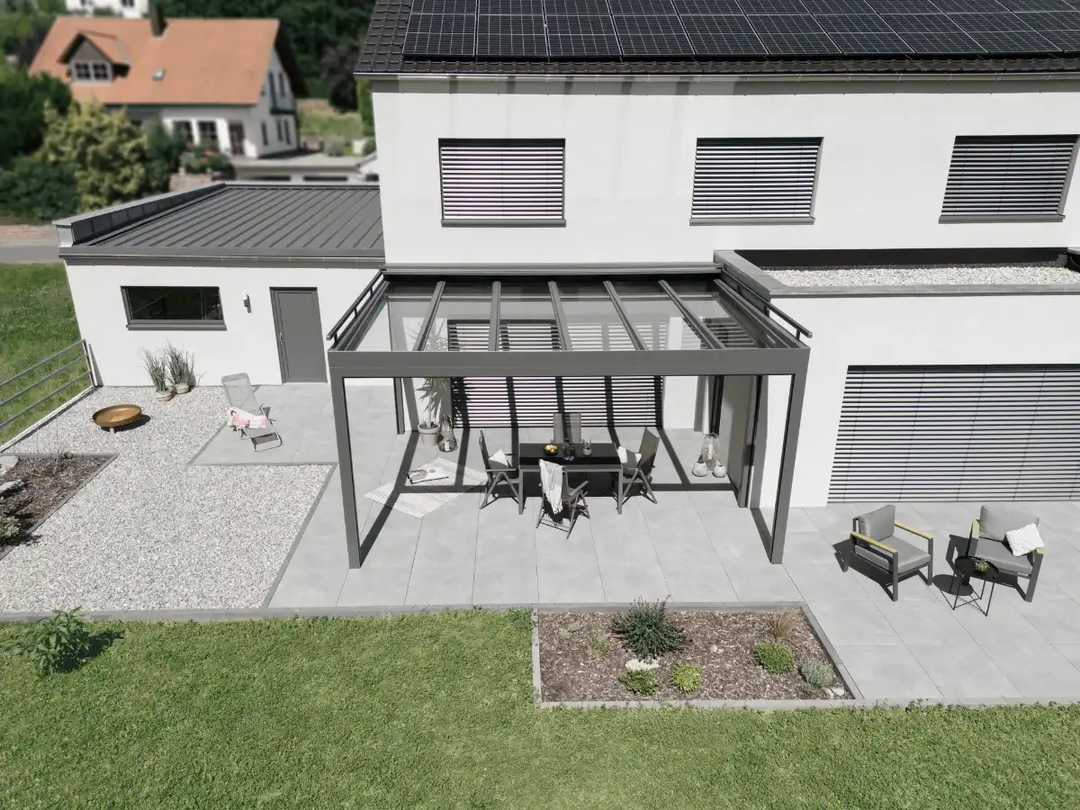 Moderne Terrasse mit Überdachung und Solaranlage auf dem Dach eines Einfamilienhauses