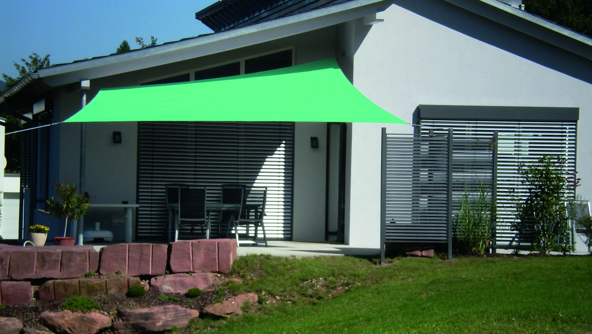 Moderne Terrasse mit grünem Sonnensegel